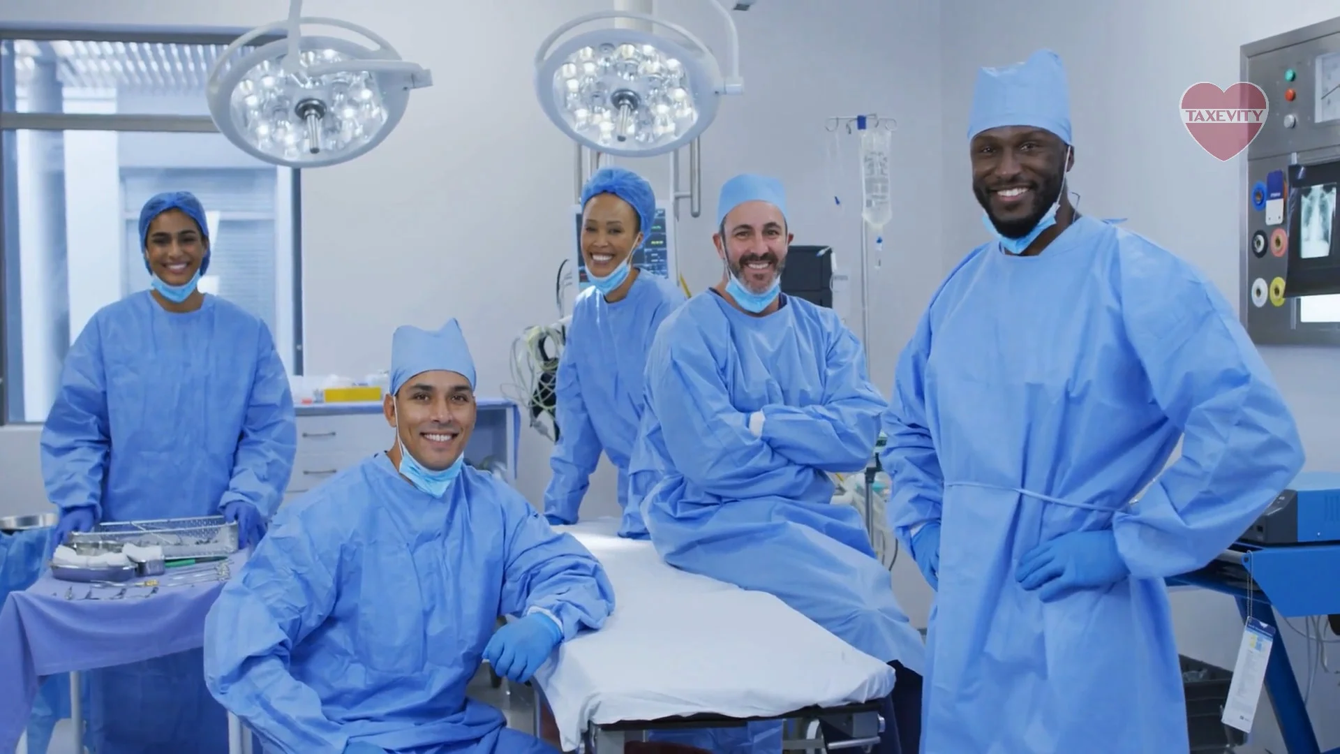 A group of smiling medical students, residents and fellows in an operating room, protected with insurance.