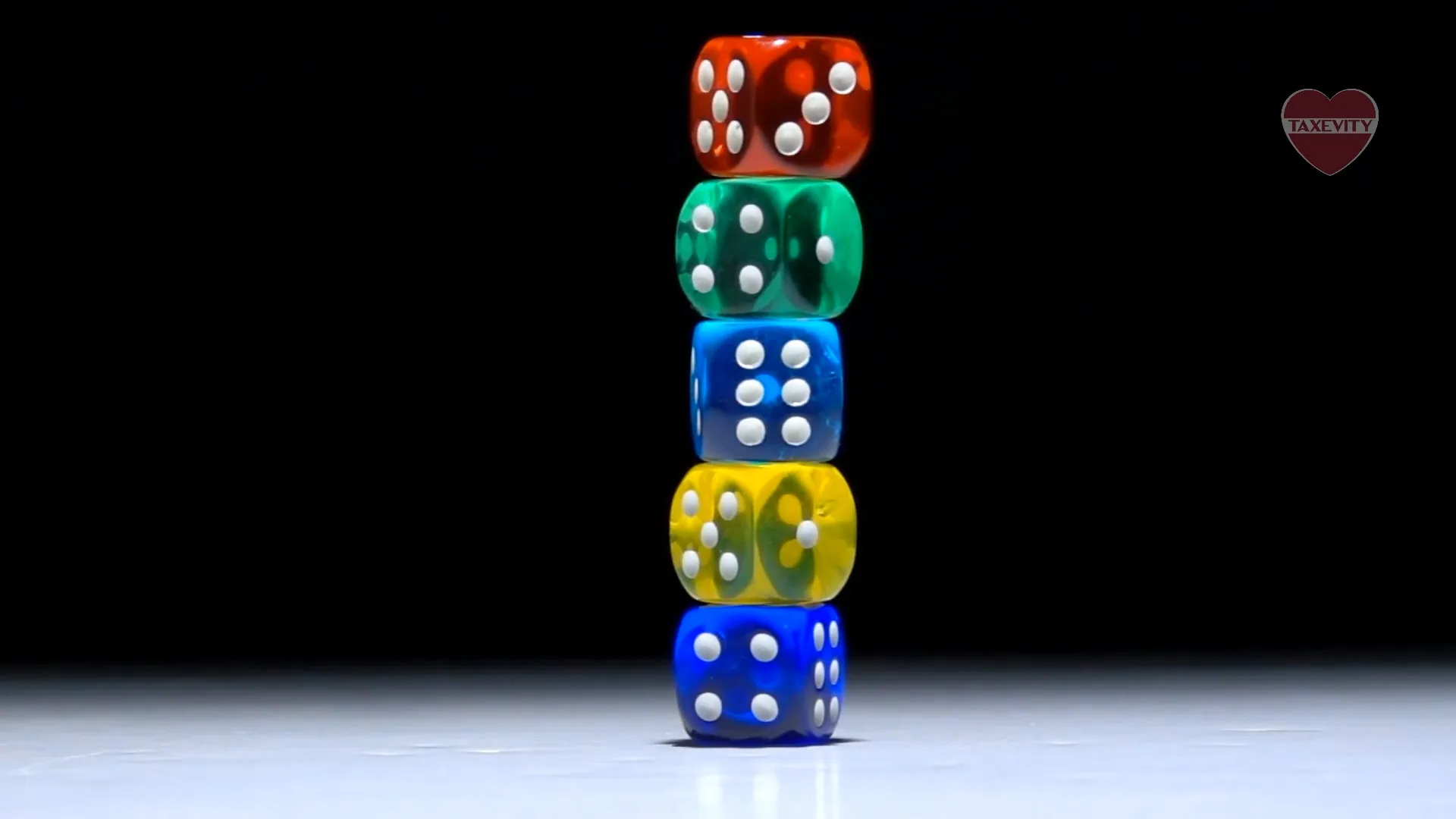 A stack of colorful dice on a black background with a philanthropic twist.